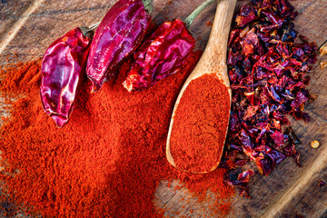 red hot dry chili pepper and paprika on wood background