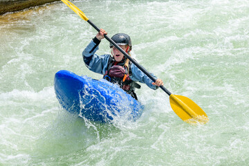 Junge Sportlerin hat Spass beim Kayaking im Wildwasser