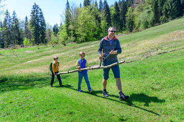 Lustige Maibaum-Zeremonie mit Kindern in frühlingshafter Natur