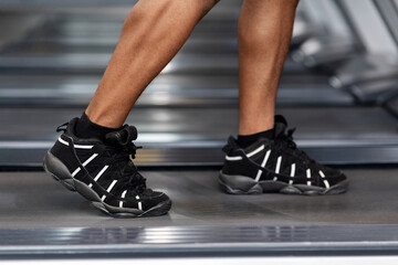 Closeup of black man legs walking by treadmill