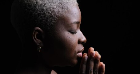 Woman praying with hands joined over black background - Powered by Adobe