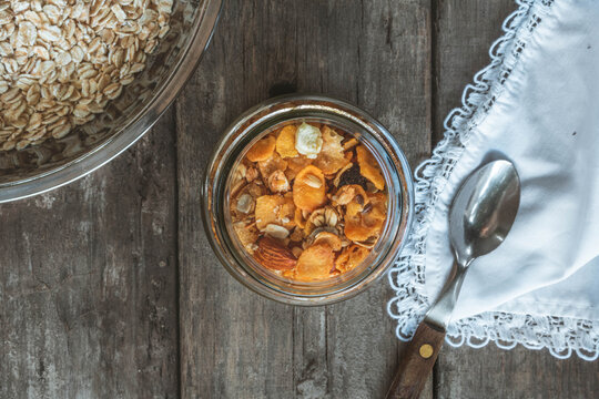 cereales sobre la mesa con plata de avena y una cuchara sobre mantel blanco.