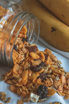 frutos secos nutritivos con bananas sobre mantel blanco.