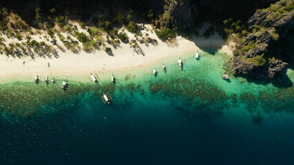 aerial drone tropical island and sand beach with palm trees. Malajon Island, Philippines, Palawan. tourist boats on coast tropical island. Summer and travel vacation concept. beach and blue clear sea