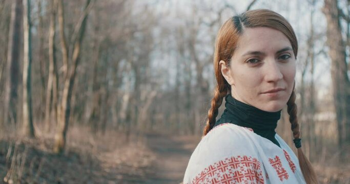 Portrait of a traditional Romanian dressed woman in the forest.