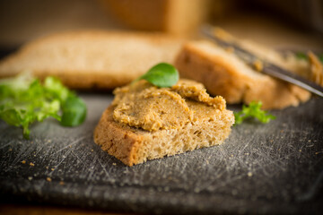homemade meat pate with bread on a wooden table