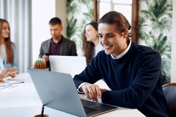 Focused young businessman in eyewear wearing holding video call with clients on laptop. Concentrated millennial man in glasses giving online educational class lecture, consulting customer.