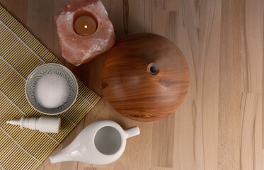 Ceramic Neti pot for nasal cleansing, wooden humidifier, salt lamp and nasal spray top view stock images. Nasal care still life images. Nasal irrigation tools stock photo