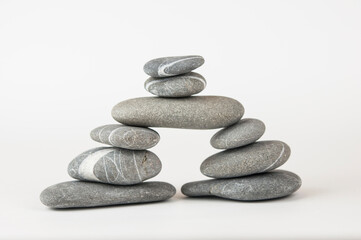 Fototapeta na wymiar Pyramid of sea pebbles on white background. Life balance and harmony concept