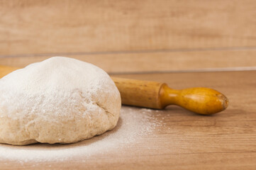 homemade pizza dough with rolling pin on the wooden table