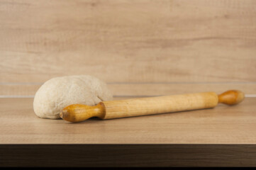 homemade pizza dough with rolling pin on the wooden table