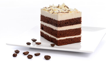 Delicious multi-layer homemade coffee sponge cake with sugar mass on a saucer with roasted coffee beans close-up.