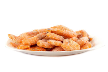 Frozen shrimps in a white plate over a white background.
