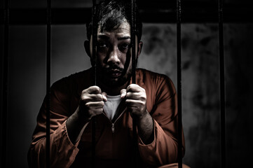 Asian man desperate at the iron prison,prisoner concept,thailand people,Hope to be free,Serious...