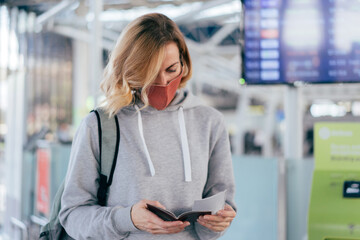 Lifestyle portrait of a woman in a medical mask at the airport. New normal life, travel during an epidemic.