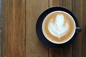 Coffee cup of cappuccino with latte art on wooden and Copy space