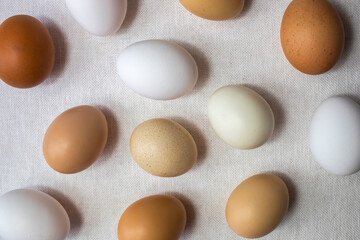 Fresh raw natural chicken eggs on white canvas. Top view.