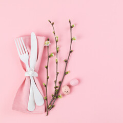 Easter holiday table setting on a pink paper background.Plates with colorful eggs. Easter holiday concept .Top view, copy space.