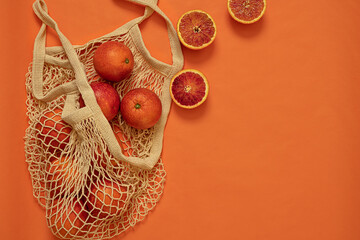 Cotton string  bag with oranges.The concept of Zero waste. Top view with copy space. Modern reusable shopping.