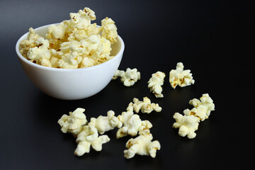caramel popcorn in a ceramic bowl on a black background