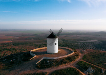 Fototapeta premium windmill on the mountain in european fields castile la mancha don quixote evening light air plane