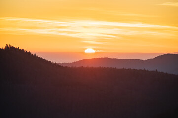 Aufgehende Sonne hinter Berglandschaft