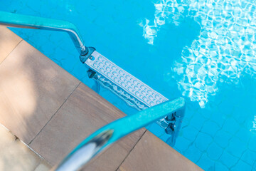 Ladder stainless handrails for descent into swimming pool. Swimming pool with handrail . Ladder of...