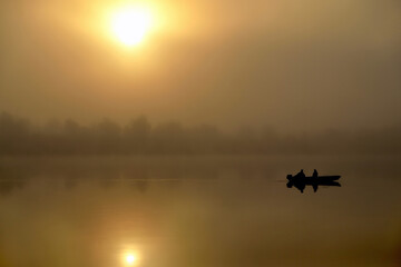 Morning. river, silhouette of a boat and fishermen, beautiful sunlight, reflection in the water of trees and the sun, a married couple in a boat, morning fishing, trolling, blur