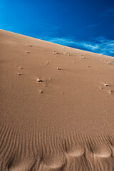Sand dune under a beautiful vivid blue sky with feathery clouds, Valle de la Luna, Atacama desert, Chile