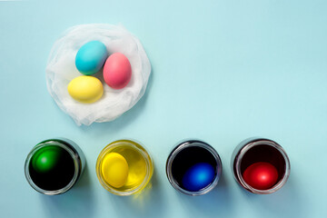 Colored easter eggs and egg dyeing set on blue background.