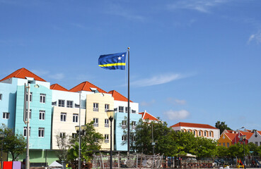 Willemstad, Curacao. Dutch Antilles.  National flag with Colourful Buildings attracting tourists from all over the world. Blue sky sunny day.