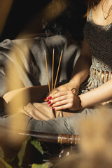 three incense sticks in the hands of a beautiful girl