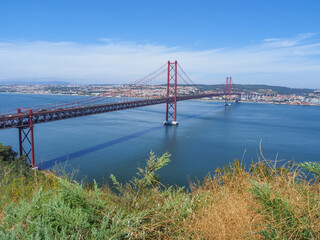 Famous Ponte 25 de Abril Bridge. Over 2km-long, red Golden Gate-style, beautiful suspension bridge links Lisbon with Almada. Panoramic view from Christ the King Square. 