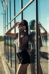 Very sexy girl talking on the phone.girl with long legs near a glass structure.Very sexy girl talking on the phone.