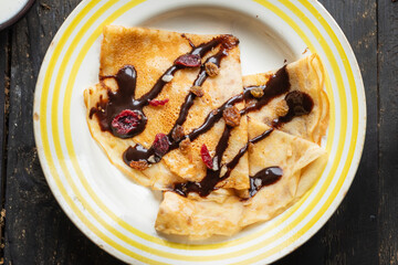crepes in a white plate thin pancakes pour chocolate syrup flat cake Shrovetide snack healthy meal top view copy space for text food background rustic