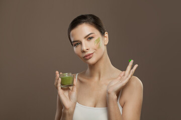 Healthy woman spa model applying organic cream to her skin. Facial treatment and skin care concept