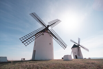 Fototapeta na wymiar two old white windmills from casilla la mancha don quixote in spain in europe blue sky