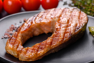 Fresh cooked delicious salmon steak with spices and herbs baked on a grill