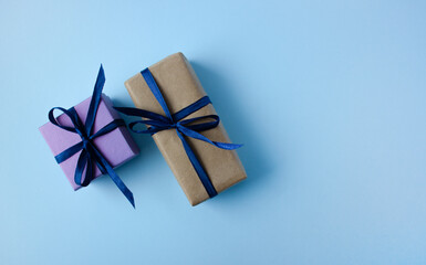 two of colorful gift box with blue ribbon and bow on blue background with copy space. Copy space