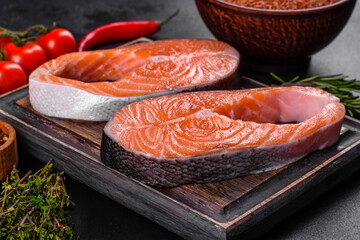Fresh raw salmon steak with spices and herbs prepared for grilled baking