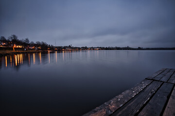 Naklejka na ściany i meble Wooden pier on the blue lake in the morning with a cloudy sky