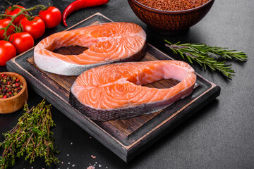 Fresh raw salmon steak with spices and herbs prepared for grilled baking