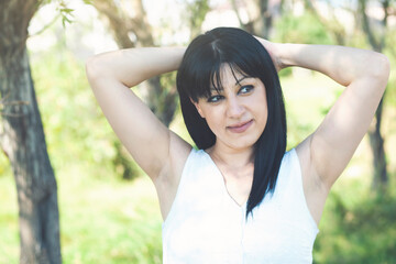 Young beautiful woman with long black hair posing in the park