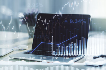 Double exposure of abstract creative financial chart on modern laptop background, research and strategy concept