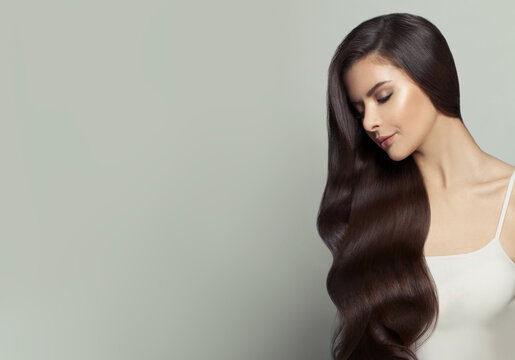 Beautiful woman with long healthy hair on white background. Haircare and facial treatment concept