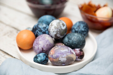 Fototapeta na wymiar Easter. Getting ready for Easter, coloring the eggs with natural dyes. Bowls with hibiscus paint, onions, turmeric on a light wooden table.. close plan