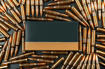 Background from rifle cartridges on a gray metal back. A box of cartridges.  Copy space for text in...