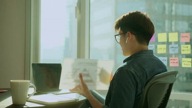 casual business discussion meeting asian male freelance work hand hold business chart and laptop presenting new product project to his co worker partner at hotel with freshness ideas and enthusiasm,