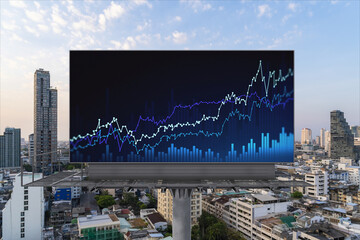 Glowing FOREX graph hologram on billboard, aerial panoramic cityscape of Bangkok at sunset. Stock and bond trading in Southeast Asia. The concept of fund management.