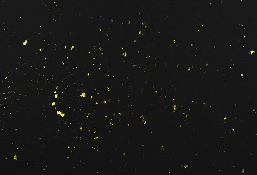 Gold flakes of potal on black textured paper